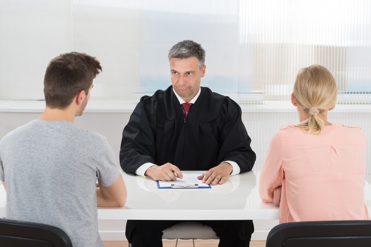 Male Judge Sitting In Front Of Couple