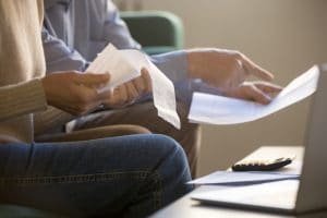 close-up-people-looking-at-bills-and-reciepts